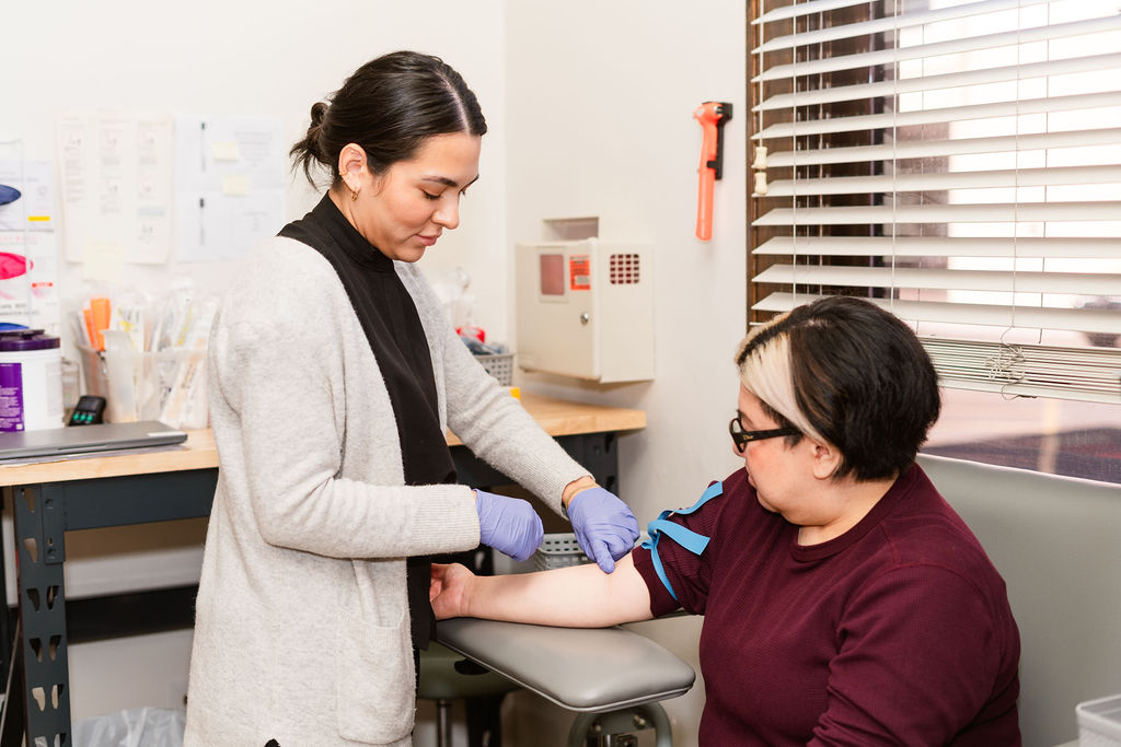 lab tech administering a blood draw on patient.