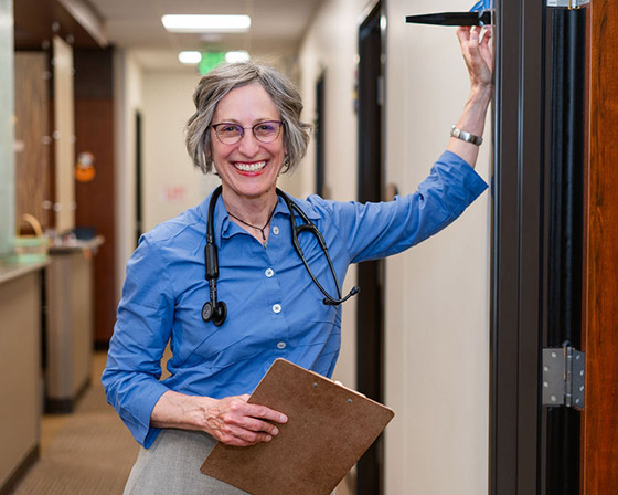 smiling provider leaning against the wall